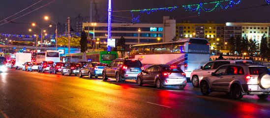 Night city, traffic jam, winter, Christmas holiday, the city is decorated with New Year illumination