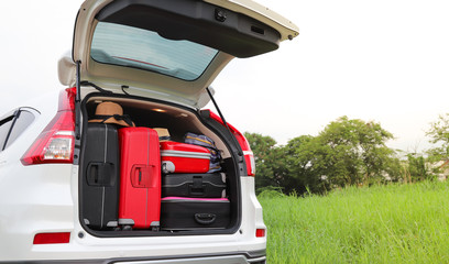 Closeup of rear or back side of white car carrying luggage, suitcases with natural background. Preparation for lovely family holiday. 