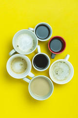 Obraz na płótnie Canvas Assortment of Coffee Cups with Coffee Espresso Capuccino Coffee with Milk on a Yellow Paper Background Flat Lay Top View Horizontal