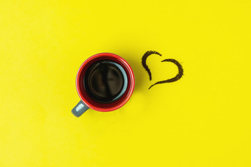 Cup of Espresso Black Coffee and Heart made of Coffee on Yellow Background Horizontal Top View