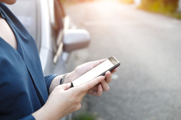 Cropped shot view of business woman’s hands holding the mobile phone with blank copy space screen for your  content or text message, the woman reading text message on the smart phone in the car.