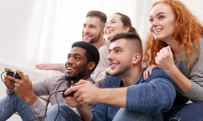 Diverse friends having fun and play video games together © Prostock-studio