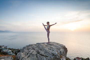 girl practices yoga at sunrise