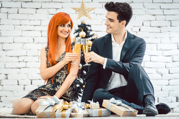 Ginger haired woman and man clinking glasses for Christmas