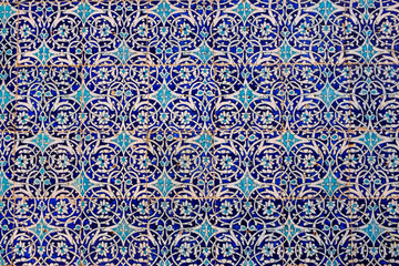 Maiolica style tin-glazed pottery tiled wall in ancient Khiva mosque in Uzbekistan. Abstract art background.