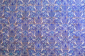 Maiolica style tin-glazed pottery tiled wall in ancient Khiva mosque in Uzbekistan. Abstract art background.