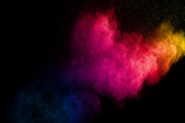 Colorful powder explosion on black background. Abstract pastel color dust particles splash.