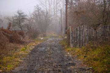 Fototapeta premium Грязная размытая сельская дорога в русской деревне