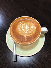 Delicious coffee cappuccino with cinnamon on wooden table