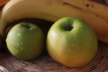 Green apples and bananas on the table