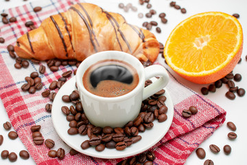 Cup of coffee with oranges and pastries. Coffee with croissant. Coffee for breakfast.