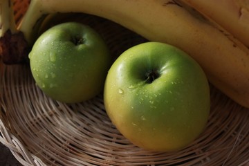 Green apples and bananas on the table