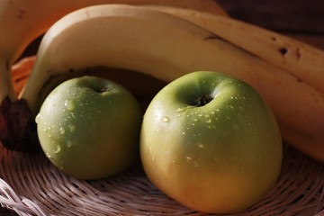 Green apples and bananas on the table