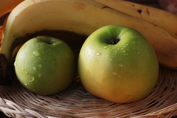 Green apples and bananas on the table
