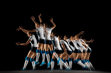Young female volleyball player isolated on black studio background. Woman in sport's equipment and...