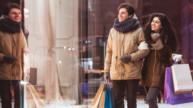 Couple Doing Winter Shopping Carrying Shopper Bags In Night City