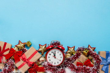 Red alarm clock, Christmas decorations, gifts on a blue background. Merry Christmas and happy new year concept. Copy Space. Flat lay, top view