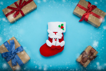 Christmas stocking for gifts and gift boxes on a blue background with snow. Concept of gifts for Merry Christmas and Happy New Year. Minimalism style. Flat lay, top view