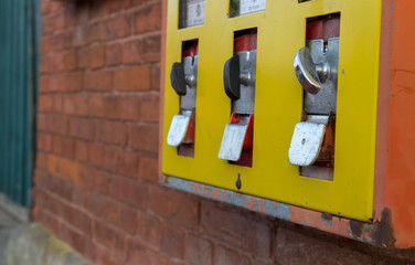 old yellow gumball machine hanging on a wall