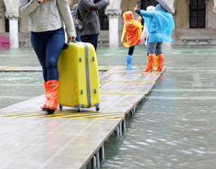 pedestrian walkways at high tide in Venice in Italy and tourists
