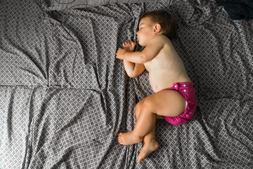 Sleeping baby with cloth diaper. Top view. Ecology reusable organic diaper. Copy space