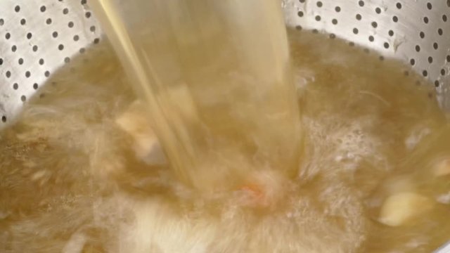pouring fresh cooked beef stock into a strainer closeup 4k