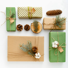 Zero waste Christmas composition background made of pine cones, branches, candle, tree rings, crafted gifts with no plastic on white table. Top view, close up, copy space, background, flat lay, square