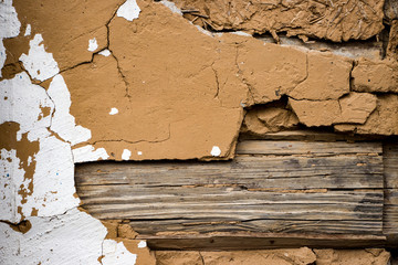 Wall of an old log house. Clay and wood. Wooden slats. Old stucco. Grunge background and texture....