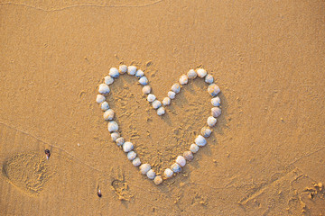 On the sand shells lined with heart and word love