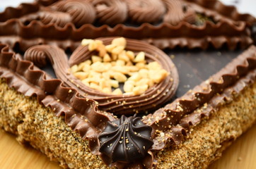Shortcake with nuts decorated with chocolate cream. Close-up. Cup of tea, a slice of lemon on the table.