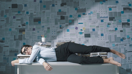 Exhausted businesswoman sleeping on the desk