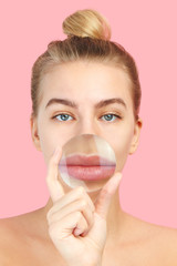 Beautiful young european woman with magnifying glass is about to do lip augmentation procedure...
