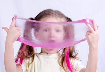 Adorable little girl holding slime toy, worldwide popular self made toy. Kid playing with slime...