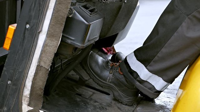 Close-up of the feet of a forklift driver.The loader driver at work