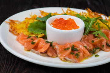 Plate with potato pancakes salmon fish and red caviar