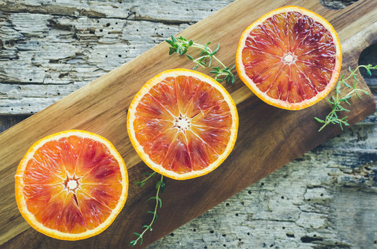 Sliced blood oranges on wooden board