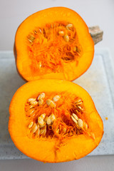 Pumpkin cut in half on the chopping board for cooking