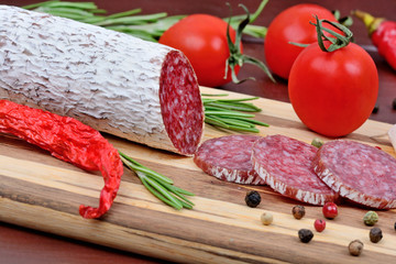 Salami with cherry tomatoes, rosemary and colorful peppercorns