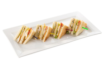 Club sandwiches with chicken, bacon, cheese and pickle isolated on white background