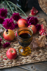 Harvest of red apples, grapefruit with glass of red wine, autumn leaves and flowers