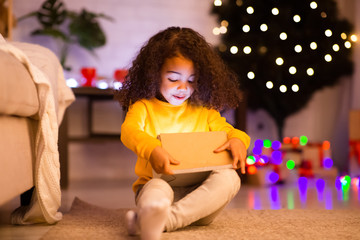 Little african american girl opening magic Christmas gift box