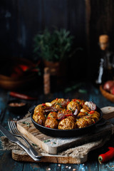 Baked potatoes in cast-iron pan with onion, garlic and herbs. Dish for dinner. Close up view. 