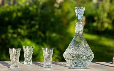 crystal decanter and glasses in the summer garden