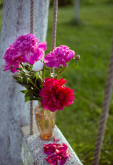 bouquet of flowers on a wooden swing in a glass vase
