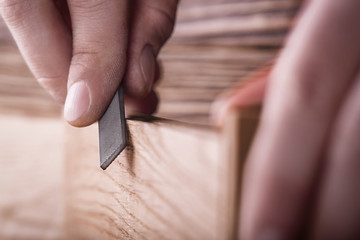 carpenter using  rasp or file handles wooden oak plank