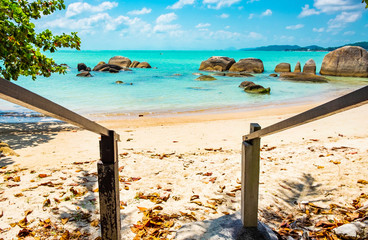 Uitweg naar het prachtige tropische strand met grote stenen en turquoise water in Thailand, het eiland Koh Samui
