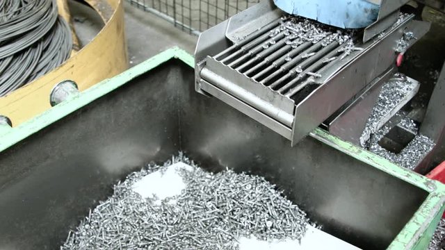 Manufactured nails fall off conveyor-belt in collection bin