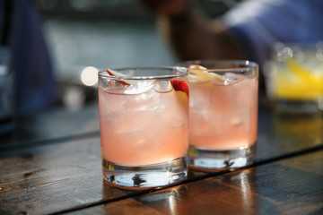 glass of water with ice and lemon on wooden table