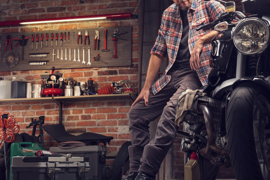 Man in a bike workshop working on a vintage motorcycle