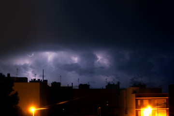 Naklejka na ściany i meble night thunderstorm with lightning between clouds